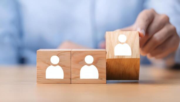Hand placing wooden block with person icon, symbolizing teamwork, recruitment, or human resources. photo