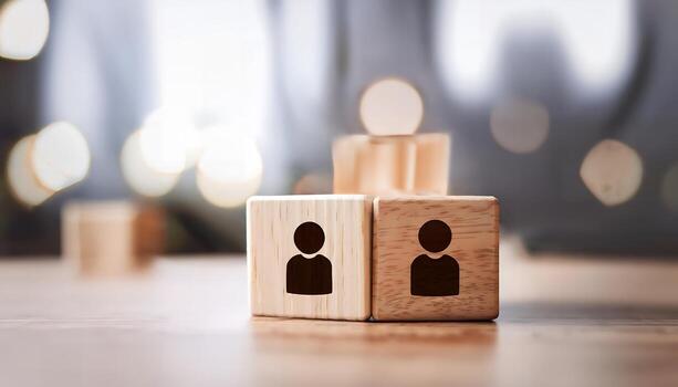 Two wooden blocks with person icons, representing teamwork or partnership. photo