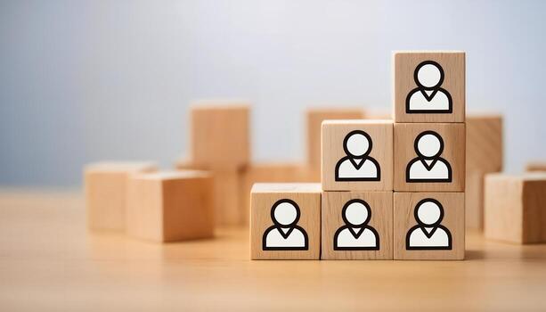 Wooden blocks forming a hierarchical pyramid with human icons, symbolizing team structure, leadership, and growth. photo