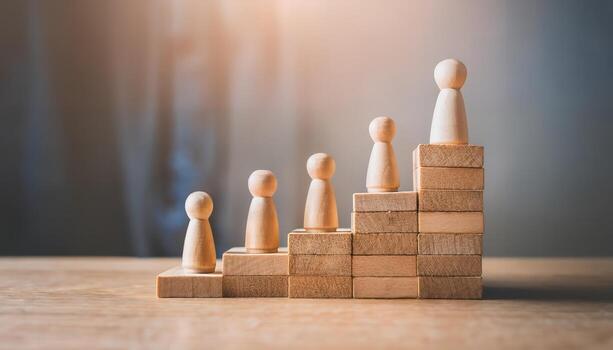 Wooden figures ascending a staircase of blocks, symbolizing growth and success. photo