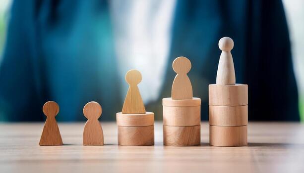 Wooden figures on stacked blocks showing career growth. photo