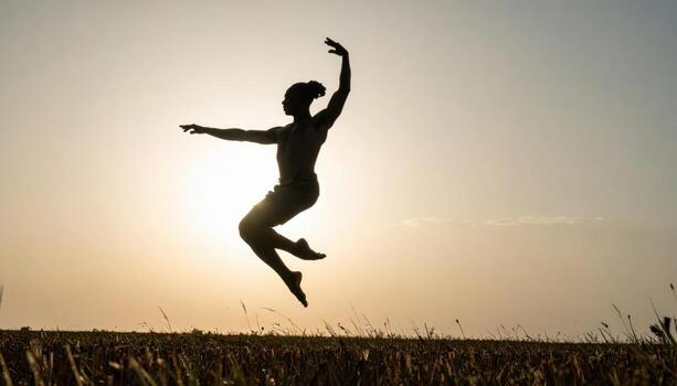 Dancer silhouette in a leap against pale sky clean composition with open sky band minimal background for banner poster and lifestyle design photo