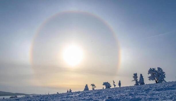 Parhelion sun dog in a pale winter sky frosty atmosphere with wide left side copy space calm optical sky background photo