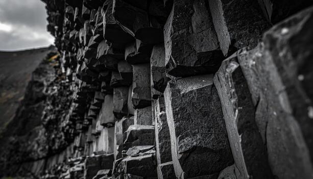 Volcanic basalt columns extreme close up dark matte geometry with left copy space rugged natural texture background photo