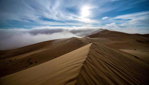 Moonlit dunes under fast moving clouds with low fog skimming the crests cool desaturated cinematic landscape background photo