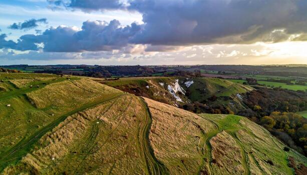 Chalk downs rolling under racing clouds with sheep tracks representing soft pastoral hills and airy movement suitable for travel inspiration editorial spreads and countryside design photo