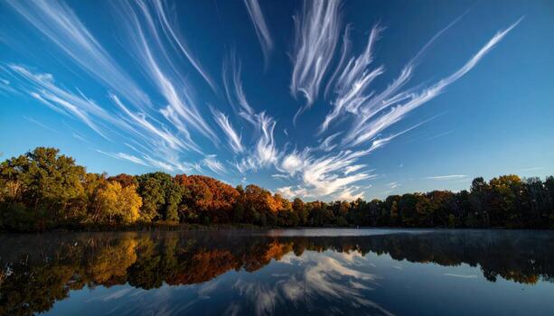 Sky full of fallstreak virga fingers mirrored on a calm lake representing gentle precipitation optics suitable for science education travel inspiration and clean design photo