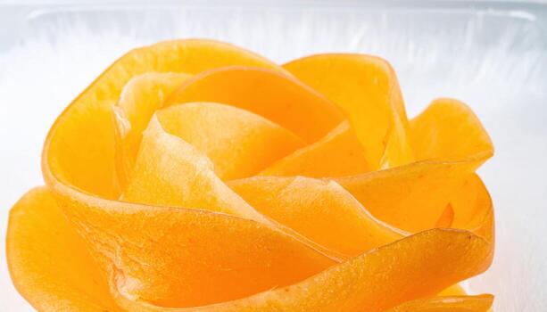 Apricot skins peeled thin and draped as translucent layers on frosted glass professional food texture still life for editorial culinary and modern packaging backgrounds photo