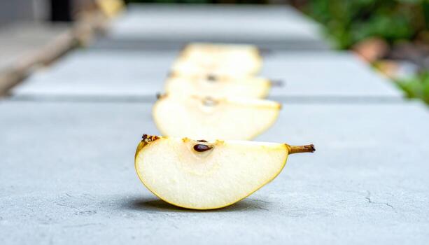 Pear cross sections aligned like stepping stones on cool concrete with shallow depth modern produce still life for editorial menus wellness features and clean branding layouts photo