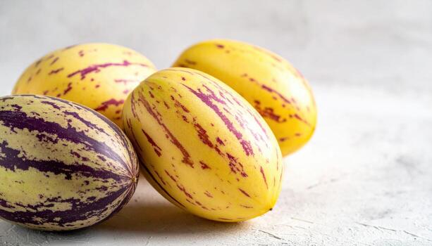 Pepino melon skins with lavender stripes arrayed as gentle waves on light stone refined texture study for editorial food stories packaging and calm backgrounds photo