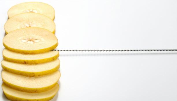 Quince slices stained pale gold stacked edge up thin top beam aligning neat serrations refined fruit study for editorial menus and clean design photo