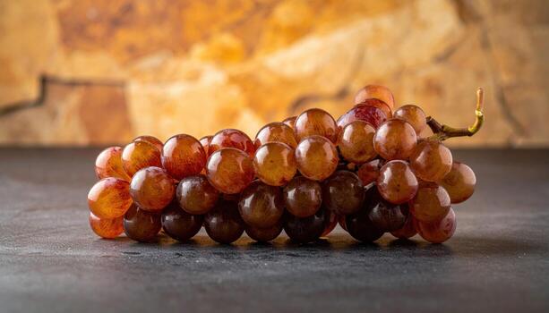 Scuppernong bronze grapes aligned in a shallow S curve on warm stone restrained speculars refined southern vineyard still life for editorial and branding photo