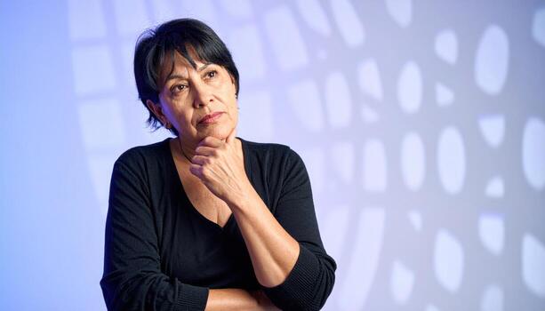 Adult in deep thought hand lightly at chin cool overhead grid creating gradient backdrop thoughtful studio portrait for business strategy editorial and branding photo