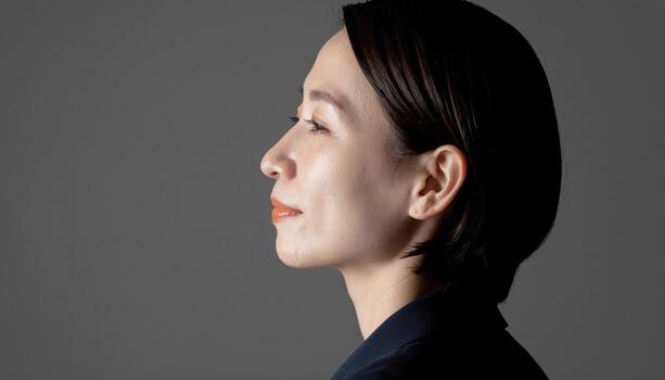 Adult in contemplative peace profile view top soft key with smooth gradient background elegant studio portrait for mindfulness education and branding photo