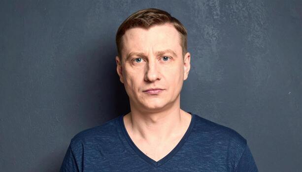 Adult with polite skepticism lips pursed narrow key from camera left on slate backdrop thoughtful studio portrait for education communication and editorial use photo