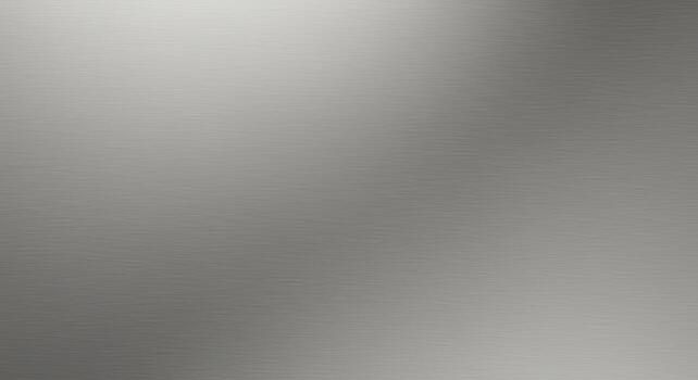 A shiny, textured metal surface reflects light, creating a smooth gradient effect that transitions from bright to subtle shadows across the entire background area. photo