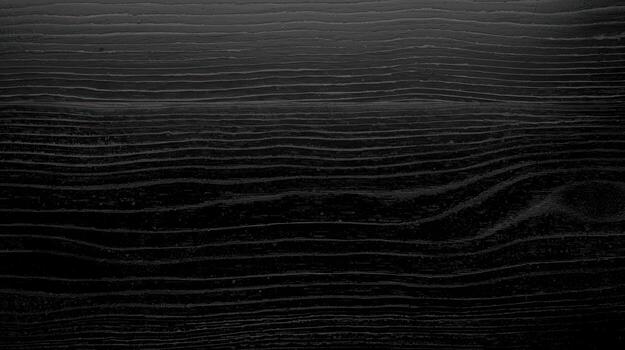 Dark wooden surface shows beautiful natural grain pattern on a flat plank with a smooth finish, presenting an organic texture and somber aesthetic appeal. photo