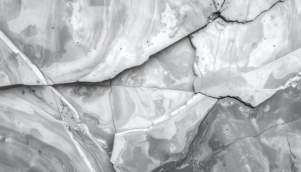 Abstract grey and white cracked rock texture creates striking patterns like marble, showcasing rough, broken surface and intricate designs in monochrome palette. photo