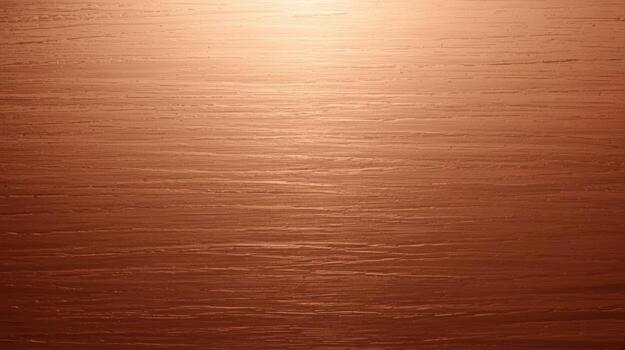 Warm amber light reflects across a textured wood surface, creating a subtle gradient from brighter highlights to deep, rich tones and subtle grain patterns. photo