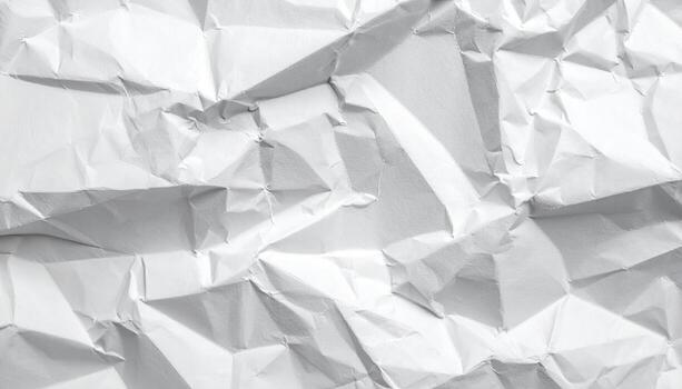 An overhead shot reveals a textured white crumpled sheet of paper showcasing abstract patterns formed by the folds and creases, evoking a sense of recycling. photo