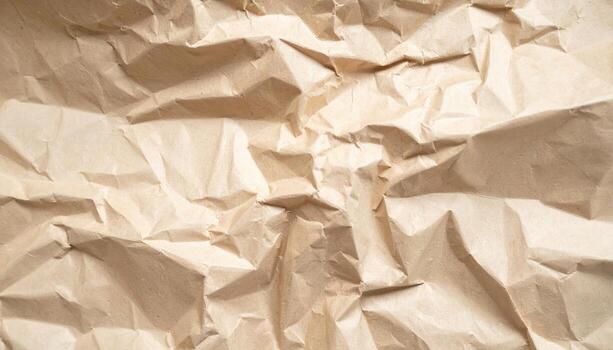 The intricately wrinkled and crumpled tan kraft paper creates a tactile and textured surface, perfect for backgrounds and abstract design elements used creatively. photo