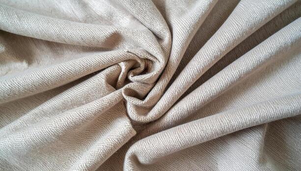 A close-up photograph reveals the intricate details of a tightly twisted beige fabric, showcasing its texture and creating soft shadows within the folds of the material. photo