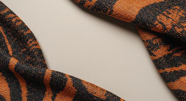 An abstract textile material displays a textured pattern of organic tiger stripes in contrasting hues of black and orange set against a neutral parchment backdrop. photo