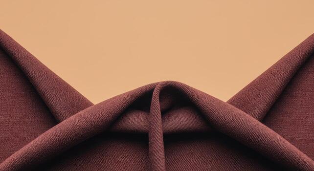 The luxurious dark red fabric is beautifully draped against a warm beige background, creating a sophisticated and elegant abstract textile pattern for design applications. photo