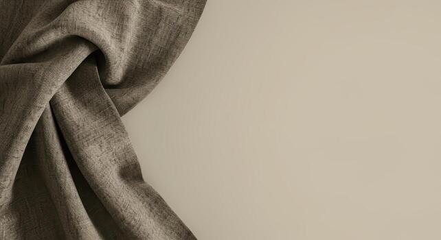 An elegantly draped light brown linen fabric casts a soft shadow across a plain beige background, creating a textured border for graphic design elements. photo