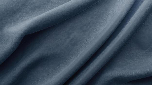 Soft blue velvet fabric drapes elegantly, showcasing its luxurious texture with subtle shadows and graceful folds creating a calming and visually appealing backdrop. photo