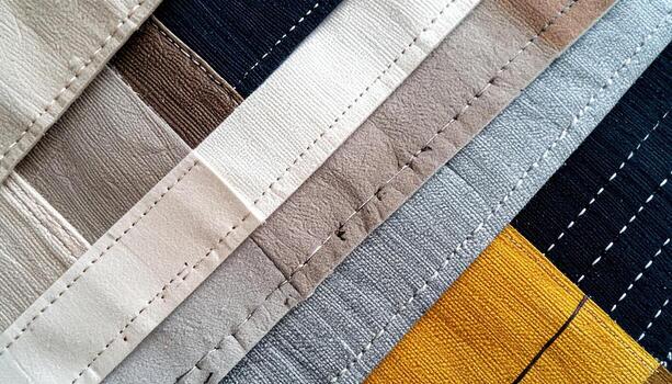 An arrangement of textile swatches and strips in varying textures and neutral colors creates an abstract pattern with parallel lines and contrasting shades of light. photo