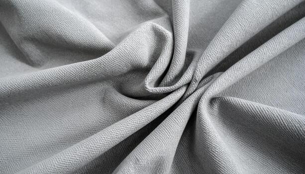 The soft, light grey fabric is draped elegantly, featu a subtle herbone texture that adds depth and visual interest to its smooth, flowing folds. photo
