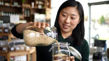 giovane donna Riempimento bicchiere vaso con cereali a massa cibo memorizzare video