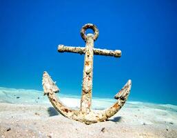 Lost at sea rusty anchor sunk on sandy bottom evokes mental health concepts photo