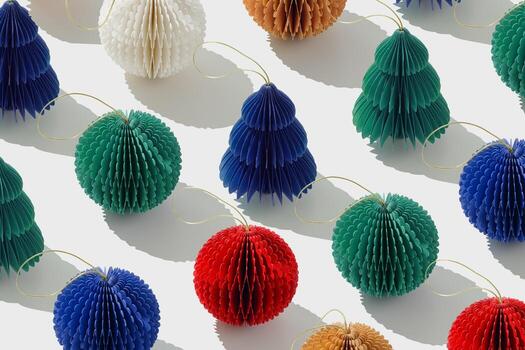 Top view of colorful honeycomb paper Christmas ornaments in minimal trend pattern on white. Bright New Year balls and Christmas tree with sunshadow, modern layout winter holiday, festive backdrop. photo
