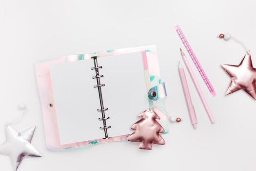 Open spiral copybook or woman diary with colorful gradient color cover, shiny Christmas decorations, blank page, copy space. Concept of planning personal future goals and ideas for New Year photo