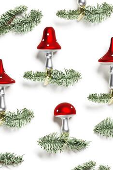 Christmas botanical pattern fly agaric mushrooms with red cap and white dots, on natural green christmas fir tree branches isolated on white background. Holiday winter decorations, flat lay photo