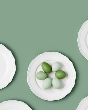 Chicken eggs with green colored eggshells on white plate. Minimal pattern with eggs and empty plate on lime green color background. Easter food concept monochrome gradient aesthetic trend photo