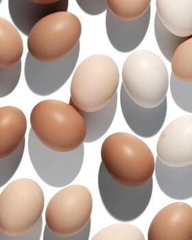 Natural eggs repeat pattern, beige brown colored Chicken egg with shadow at sunlight, creative food layout. Minimal Easter holiday concept, top view still life photo, trend geometric patterns photo