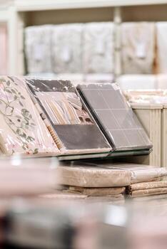 Soft textiles displayed in a retail store, featuring neatly packaged bedding sets and cushions, showcasing various colors and patterns, inviting a cozy home atmosphere photo