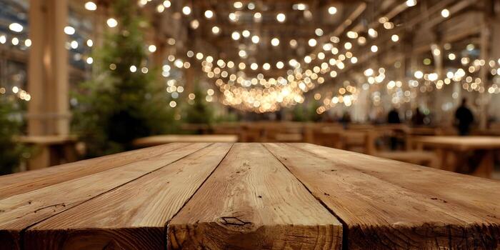 Empty rustic wooden table with bokeh string lights and blurred Christmas trees in a warm festive indoor setting photo