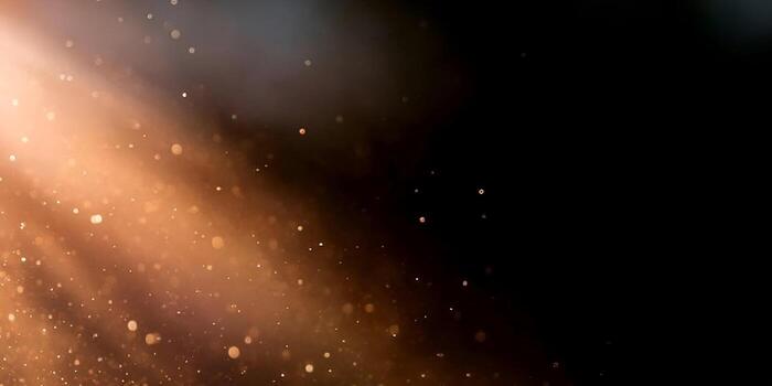 Golden light rays illuminate dust particles creating a beautiful atmospheric bokeh effect on a dark background photo