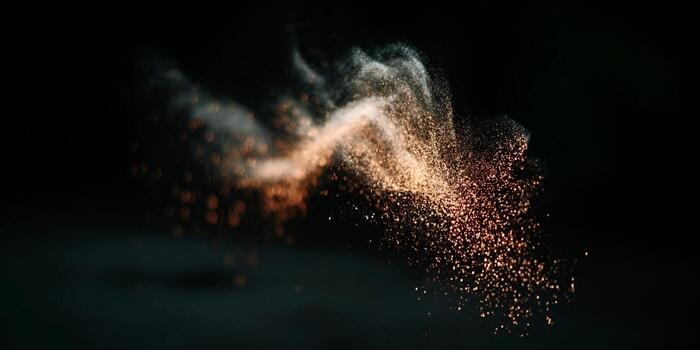 Golden orange light particles burst and swirl in a dynamic cloud against a dark abstract background photo