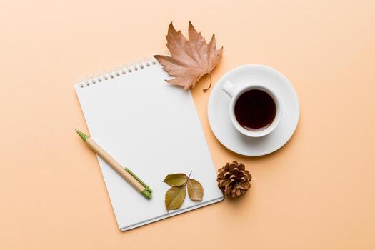 Autumn composition fallen leaves and notebook mock up on colored background. Flat lay with copy space photo