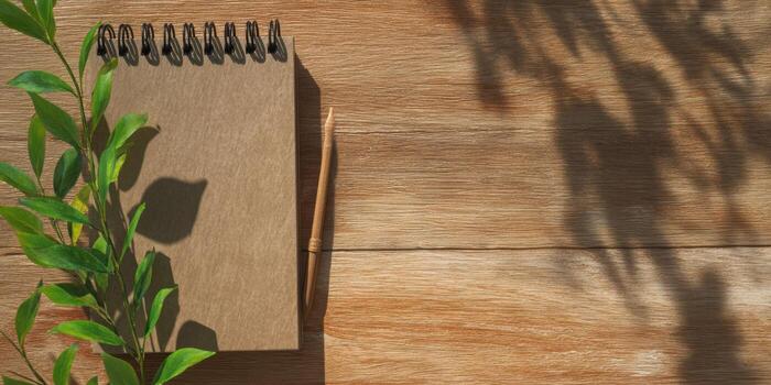 Rustic wooden table with notebook and pen for creative inspiration photo