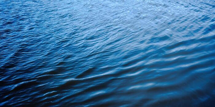 Gentle blue water waves create a soothing, abstract background with beautiful textures. photo