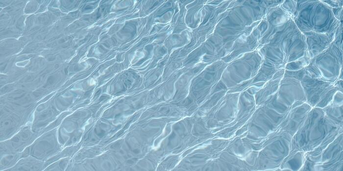 The serene water surface glistens with sunlight, creating an abstract and tranquil pattern. photo