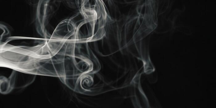Elegant white smoke spirals against a dark backdrop, creating a mesmerizing visual. photo