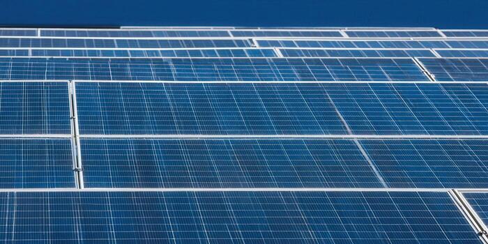 A close-up view of a solar panel field against a bright blue sky, signifying clean energy photo