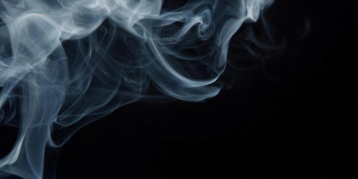 Abstract smoke gracefully swirls against a deep black backdrop, creating a sense of mystery. photo